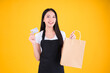 © Png - Video - Photo - asian female smile wearing black apron holding paper bag and payment with a credit card through terminal money swiping a credit card