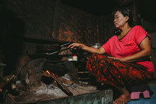 Asian Local Woman Is Cooking In Traditional Stove At Wood Cubicle Kitchen. 