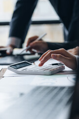 Poster - Businessman using a calculator to calculate numbers on a company's financial documents, he is analyzing historical financial data to plan how to grow the company. Financial concept.