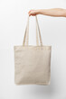 Female hand holding eco or reusable shopping bag against white background