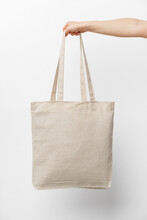 Female Hand Holding Eco Or Reusable Shopping Bag Against White Background