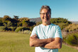 © wavebreak3 - Portrait of smiling caucasian senior man with arms crossed standing against plants and clear sky