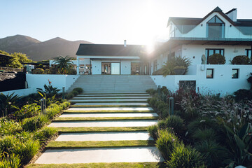 Steps amidst plants leading towards nursing home against clear sky during sunny day, copy space