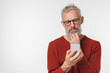 © InsideCreativeHouse - Pensive thoughtful caucasian mature middle-aged man using smart phone cellphone, thinking about buying new car, loan and cashback, social media isolated in white background