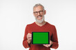 © InsideCreativeHouse - Smiling caucasian mature middle-aged man freelancer businessman holding digital tablet showing screen with green mockup copyspace free space isolated in white background