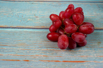 Wall Mural - a bunch of pink grapes is lying on a blue wooden table .top view