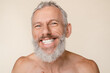 © InsideCreativeHouse - Closeup cropped caucasian mature middle-aged man with grey hair and beard smiling with toothy smile, looking at camera naked with bare shoulders shirtless isolated in beige background