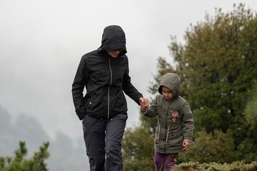 Wall Mural - Selective focus shot of mother and daughter hiking moment in nature, walking near mountain.