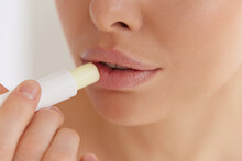 Lips Care. Close Up Of Young Woman Applying Hygienic Balm On Her Plump Lips In Studio. Charming Lady Using Professional Cosmetic For Taking Care Of Her Soft Skin.