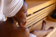 African american woman in a bathrobe relaxing in the sauna