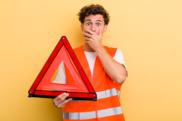 Wall Mural - young handsome guy covering mouth with hands with a shocked. car emergency triangle concept