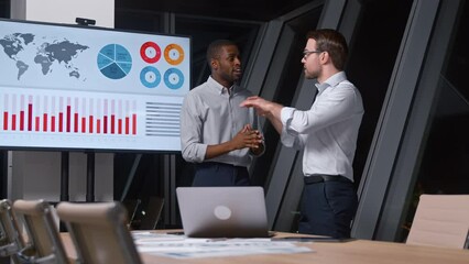 Poster - Smiling business men discussing a new business idea on the background of TV multimedia in the office