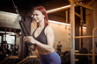 © splitov27 - Red-haired young fitness woman in sportswear trains triceps muscles in a cable crossover exercise machine in a modern gym. Healthy lifestyle, fitness and bodybuilding concept