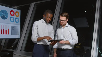 Poster - Businessmen using digital tablet together in front of office building windows