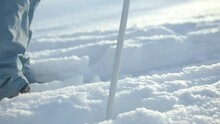 Close-up of skier with stick on winter trail. Creative. Person is preparing for ski trip on fresh snow in winter. Winter sports and skiing