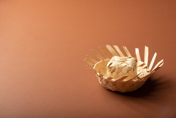 Mini straw hat used in Junina party decoration in Brazil, placed on brown background, selective focus.