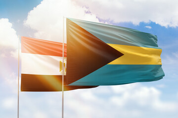 Sunny blue sky and flags of bahamas and egypt