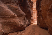 Al Siq Canyon In Petra, Jordan, Pink Red Sandstone Walls Both Sides, Unrecognizable Person Sitting On Camel Distance, Treasury Temple Behind