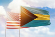 Sunny blue sky and flags of bahamas and usa