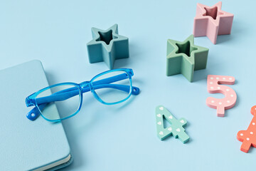 Poster - Child eyeglasses over pastel  background. Optical store, glasses selection for kids, eye test, vision examination at optician concept. Top view, flat lay