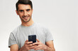 © SHOTPRIME STUDIO - portrait man in a gray t-shirt with a phone communication technology isolated background