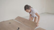 © SewcreamStudio - Young girl helping with laminated wooden floor installation, child STEM learning,  house renovation homeschooling project