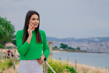 woman walking along the coast talking on the mobile phone