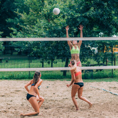 Wall Mural - Young women playing beach volleyball