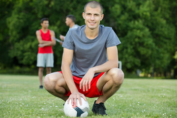 portrait of young male footballer crouching on th pitch