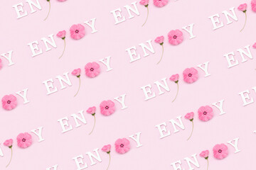 Wall Mural - Enjoy. Creative inspirational pattern made with motivational quotes from white letters and beauty natural flowers on pink background