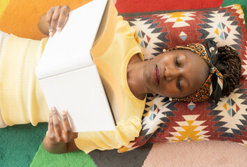 Wall Mural - young woman laying down while reading a book