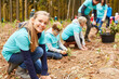 canvas print picture - Kinder und Familie als Freiwillige beim Baum pflanzen