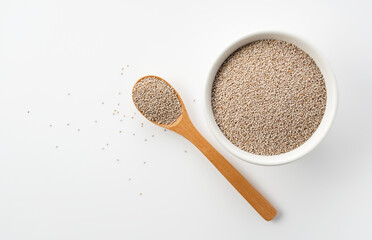 Wall Mural - White chia seeds and wooden spoon in white bowl set against white background.