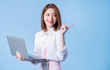 Wall Mural - Image of young Asian businesswoman on blue background