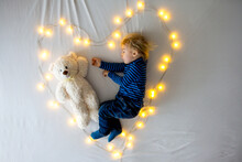 Little Baby Boy, Sleeping With Teddy Bear In Bed In Heart Made By Lights