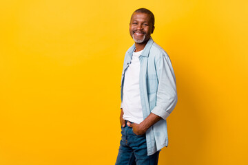 Profile portrait of cheerful nice person put hands pockets empty space ad isolated on yellow color background