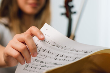 close up female hand violinist changing the page of the sheet on the music stand. focus on hand.