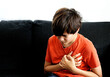 Teenager boy Caucasian holding his chest suffering from pain. Abnormal coronary artery course or origin, or diseases of heart muscle heart attack in children concept.