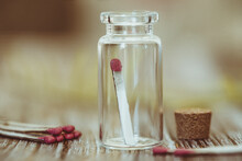Close-up Of Matchsticks In An Open Glass Jar And A Wooden Table