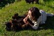Woman and tibetan mastiff dog laying on grass and playing together outdoors
