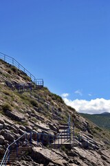 stairways down to the voda beach with blue sky and mountains in background