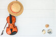 Summer music vacation background. Flatlay composition of violin, sea shell and staw hat on white wood background with copyspace, top view.