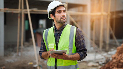 Professional male foreman worker with safety vast holding paperwork project to survey and make a check on construction building, Professional engineering working concept