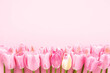 Pink tulips border on pink background. Mothers Day, Valentines Day, birthday celebration concept
