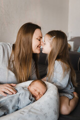 portrait of mother with newborn son and infant daughter. happy caucasian family of three people. mot