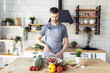 © ArtSys - Handsome father, strong young man cooking healthy vegetable salad with fresh organic ingredients, tasty food in the kitchen at home . Men doing chores. Ripe pepper, tomato, cucumber