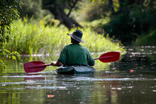 Kayaker Exploring River System In Gentle Water