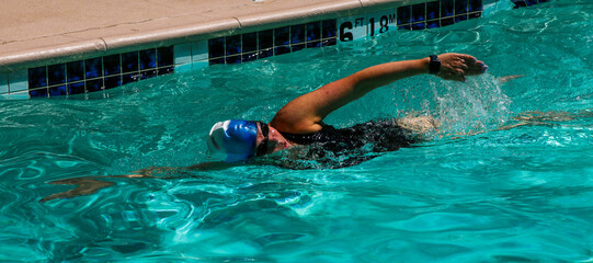 Wall Mural - Women swimming alone in a outdoor pool at a hotel