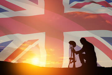 Silhouette of soldier kneeling with his head bowed against the sunrise or sunset and United Kingdom flag. Greeting card for Poppy Day, Remembrance Day. United Kingdom celebration.