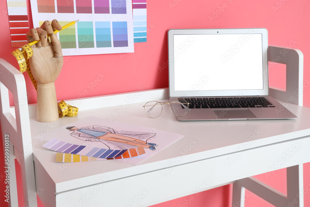 Workplace of clothes stylist near pink wall
